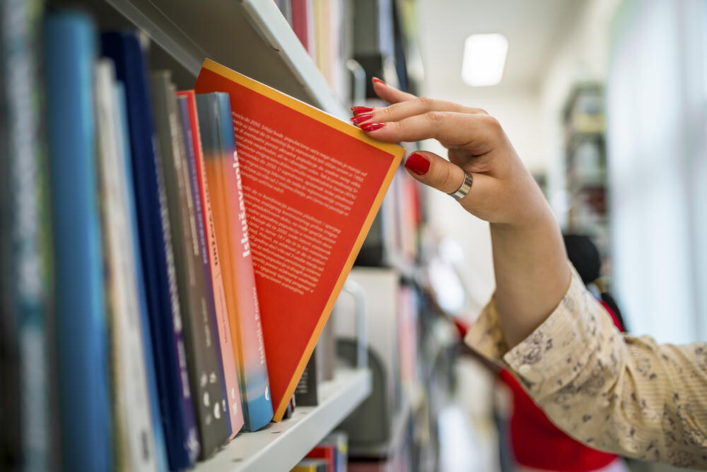 Choosing book hand red book library bookshelf