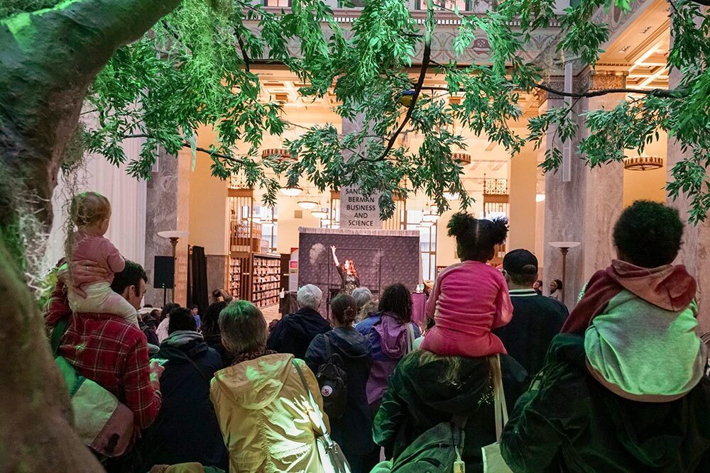 Events at Pratt Library - all ages audience under an indoor tree